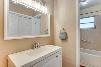 a bathroom with a sink and a mirror at 11 Mi to South Beach Home with Screened Porch! in Miami