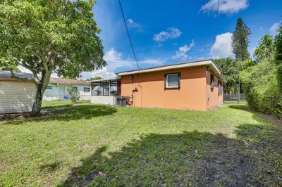 an orange house with a tree in the yard at 11 Mi to South Beach Home with Screened Porch! in Miami