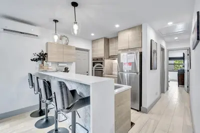 a kitchen with a white counter and stools at Contemporary 3BR 3 BA Duplex, Amazing Outdoor Area in Fort Lauderdale