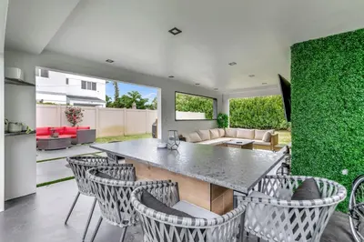 a kitchen and living room with a table and chairs at Lovely 2BR 2BA Modern Flat with Vibrant Backyard in Fort Lauderdale