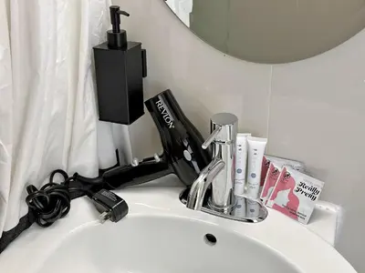 a bathroom sink with a toothbrush holder and a mirror at Ocean Drive South Beach Miami in Miami Beach