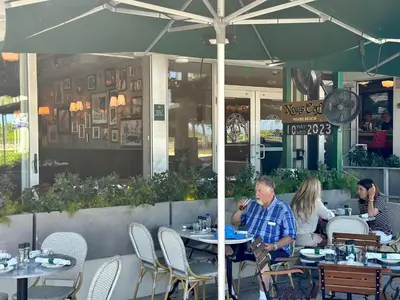 a group of people sitting at tables in a restaurant at Ocean Drive South Beach Miami in Miami Beach