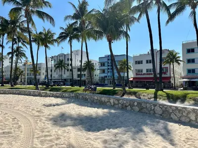 a sandy beach with palm trees and buildings at Ocean Drive Steps to Sea in South Beach with Free Parking in Miami Beach