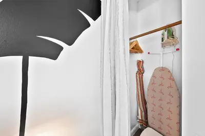 a lamp in a room with a mirror and a surfboard at Ocean Drive Oasis in Art Deco District of South Beach in Miami Beach