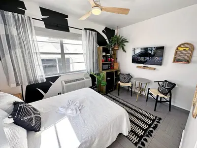 a bedroom with a white bed and a dining room at Beachfront Ocean Drive South Beach Miami in Miami Beach