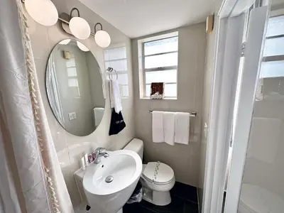 a bathroom with a sink and a toilet and a mirror at Beachfront Ocean Drive South Beach Miami in Miami Beach