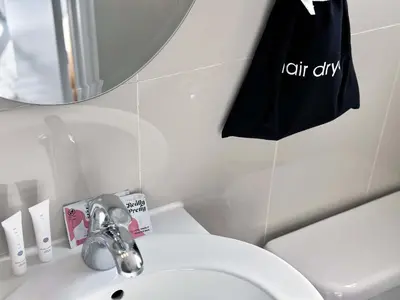 a bathroom with a sink and a black bag at Beachfront Ocean Drive South Beach Miami in Miami Beach