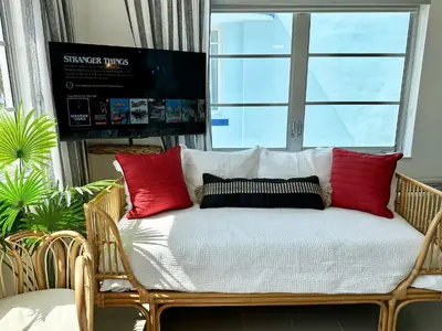 a bench with pillows on it in a room with a window at Ocean Drive Oasis Beach Views South Beach Miami in Miami Beach