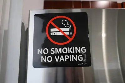 a no smoking sign on a metal pole at Spacious Private Room Close to Miami Attractions in Miami