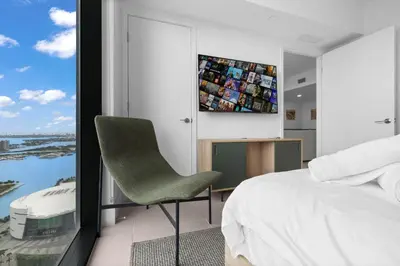 a bedroom with a green chair and a large window at Free Parking! Luxury Condo in Downtown Miami in Miami