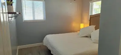 a bed in a room with a window and a bed sidx sidx sidx at Holliday 3-bedroom Private duplex House Parking WiFi BBQ Karaoke Available in Cutler Bay
