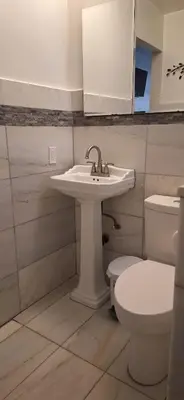 a bathroom with a sink and a toilet at Holliday 3-bedroom Private duplex House Parking WiFi BBQ Karaoke Available in Cutler Bay