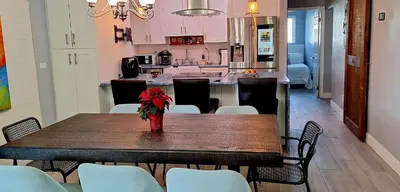 a table with a vase of flowers on it in a kitchen at Holliday 3-bedroom Private duplex House Parking WiFi BBQ Karaoke Available in Cutler Bay