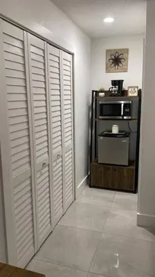 a room with white closet doors and a microwave at Private and Comfortable Suite near Airport Miami in Miami