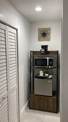 a microwave on a stand in a room with a door at Private and Comfortable Suite near Airport Miami in Miami