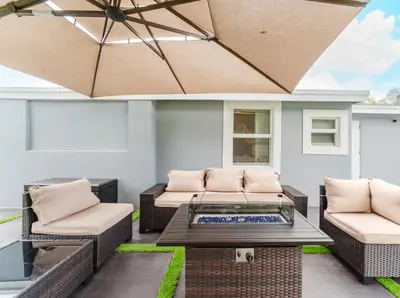 a patio with two wicker chairs and a table at BOHO Elegance in the FLL city! in Fort Lauderdale