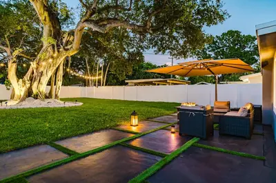 a patio with an umbrella and chairs and a table at BOHO Elegance in the FLL city! in Fort Lauderdale