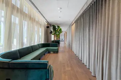 a waiting room with green couches and curtains at NEW Luxurious Apartment Floor 35th - Miami's heart in Miami