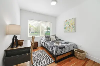 a bedroom with a bed and a desk and a window at Charming House with Private Pool n Coral Gable in Miami