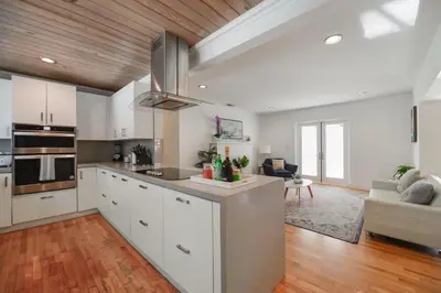 a kitchen with white cabinets and a living room at Charming House with Private Pool n Coral Gable in Miami
