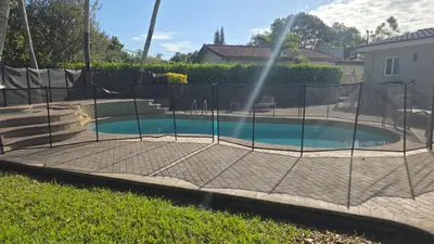 a batting cage in a backyard with a pool at Charming House with Private Pool n Coral Gable in Miami