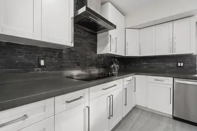 a white kitchen with white cabinets and a sink at Emerald Hills Haven in Hollywood