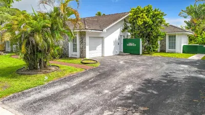a house with a driveway in front of it at Emerald Hills Haven in Hollywood