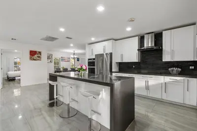 a kitchen with white cabinets and a black counter top at Emerald Hills Haven in Hollywood