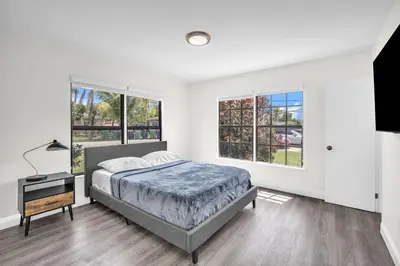a bedroom with a bed and two windows at Contemporary 4 Bedroom Oasis - Private Large Patio in North Miami