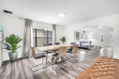 a dining room with a table and chairs and a couch at Contemporary 4 Bedroom Oasis - Private Large Patio in North Miami