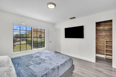 a bedroom with a bed and a flat screen tv at Contemporary 4 Bedroom Oasis - Private Large Patio in North Miami