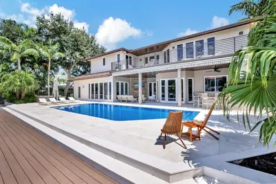 a home with a swimming pool and a house at Elegant Waterfront Estate 6BR- 6.5BA in Fort Lauderdale