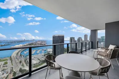 a balcony with tables and chairs and a view of the city at Lux Downtown Miami w Free Parking in Miami