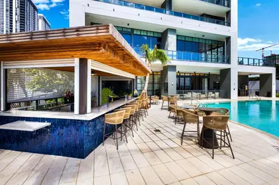 a building with a swimming pool and a patio with tables and chairs at Free Parking! PH Luxury 3BR in Downtown Miami in Miami