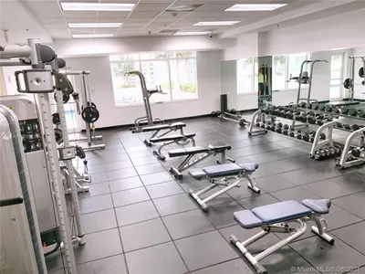 a gym with several rows of treadmills and machines at Amazing 28th floor unit with Parking in Miami