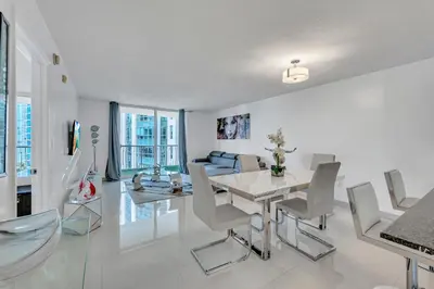 a white living room with a table and chairs at Amazing 28th floor unit with Parking in Miami