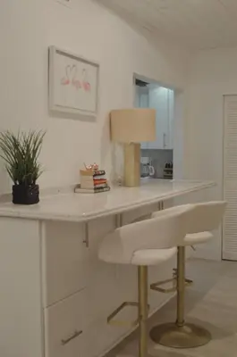 a white kitchen with a desk with a lamp and a chair at Amazing beachfront condo at Tides on Hollywood Beach Luxury Resort in Hollywood