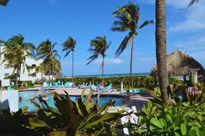 a pool at a resort with palm trees at Amazing beachfront condo at Tides on Hollywood Beach Luxury Resort in Hollywood