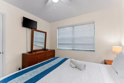 a bedroom with a bed and a mirror and a window at Spacious 5BR Home with Pool, Near Downtown & Beach in Hollywood