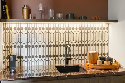 a kitchen with a sink and a tile wall at The Rover Miami in Miami