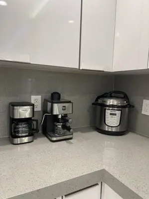 a kitchen counter with three coffins and a coffee maker at Flamingo Paradise in Hialeah