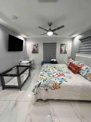a bedroom with a bed and a flat screen tv at Flamingo Paradise in Hialeah
