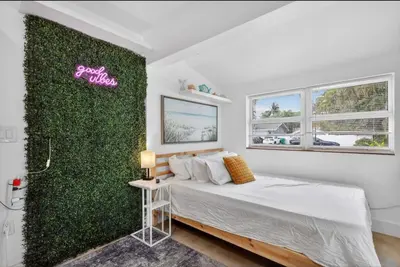 a bedroom with a green wall with a bed at Fort Lauderdale airport and Dania Pointe shopping 5 min away in Fort Lauderdale