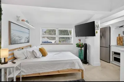 a white bedroom with a bed and a desk at Fort Lauderdale airport and Dania Pointe shopping 5 min away in Fort Lauderdale