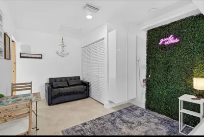 a living room with a couch and a green wall at Fort Lauderdale airport and Dania Pointe shopping 5 min away in Fort Lauderdale