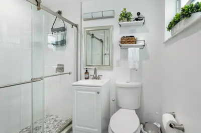 a white bathroom with a toilet and a shower at Ocean Views! Steps from Dining, Shopping, Las Olas in Fort Lauderdale