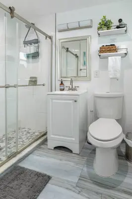 a white bathroom with a toilet and a shower at Ocean Views! Steps from Dining, Shopping, Las Olas in Fort Lauderdale