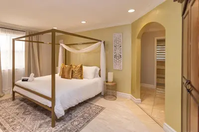 a bedroom with a canopy bed with gold pillows at Miami House - Heated Pool - Family Vacation in Miami