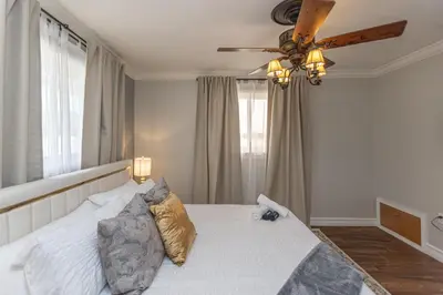 a bedroom with a white bed with a ceiling fan at Miami House - Heated Pool - Family Vacation in Miami