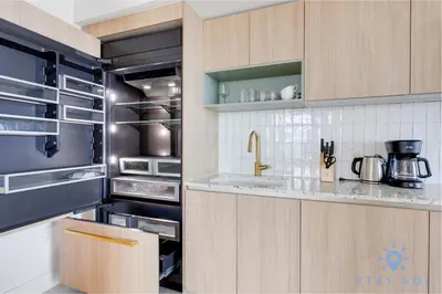 a kitchen with wooden cabinets and a stainless steel refrigerator at Apartment 3BR-3 BTH - Gym & Pool in Miami